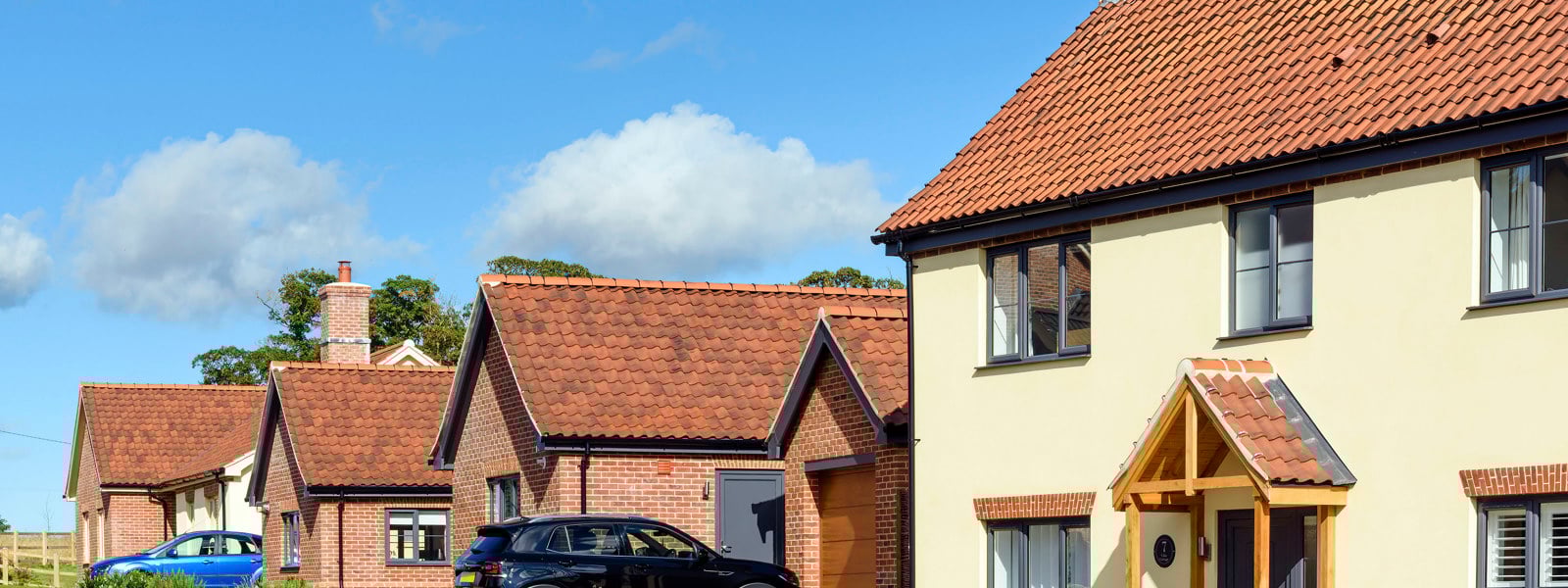 New-build homes with red tile roofs